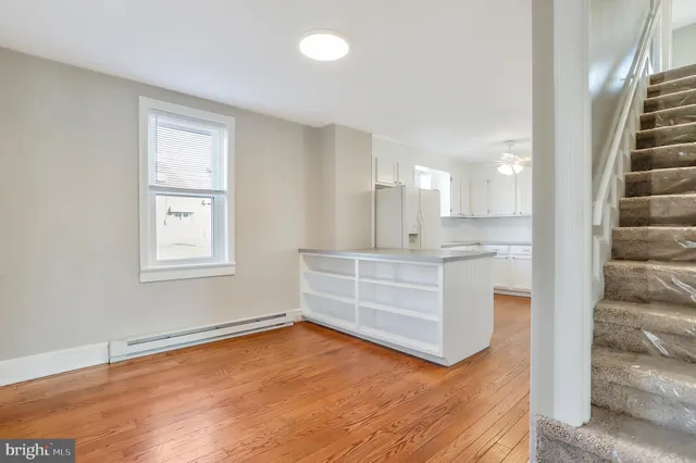a room with kitchen island wooden floor and view living room