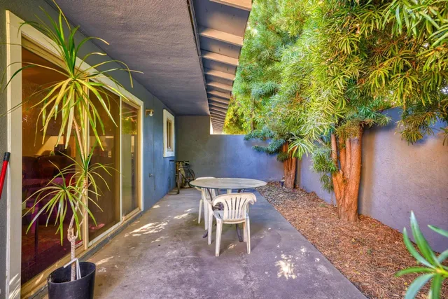 a view of a patio with a table and chairs and potted plants