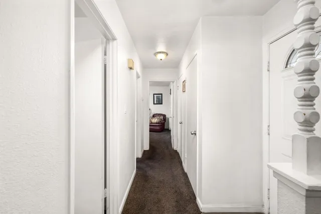 a view of a hallway with a closet and a bathroom
