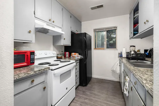 a kitchen with stainless steel appliances granite countertop a stove and a refrigerator