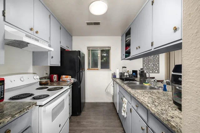 a kitchen with stainless steel appliances granite countertop a sink stove and refrigerator