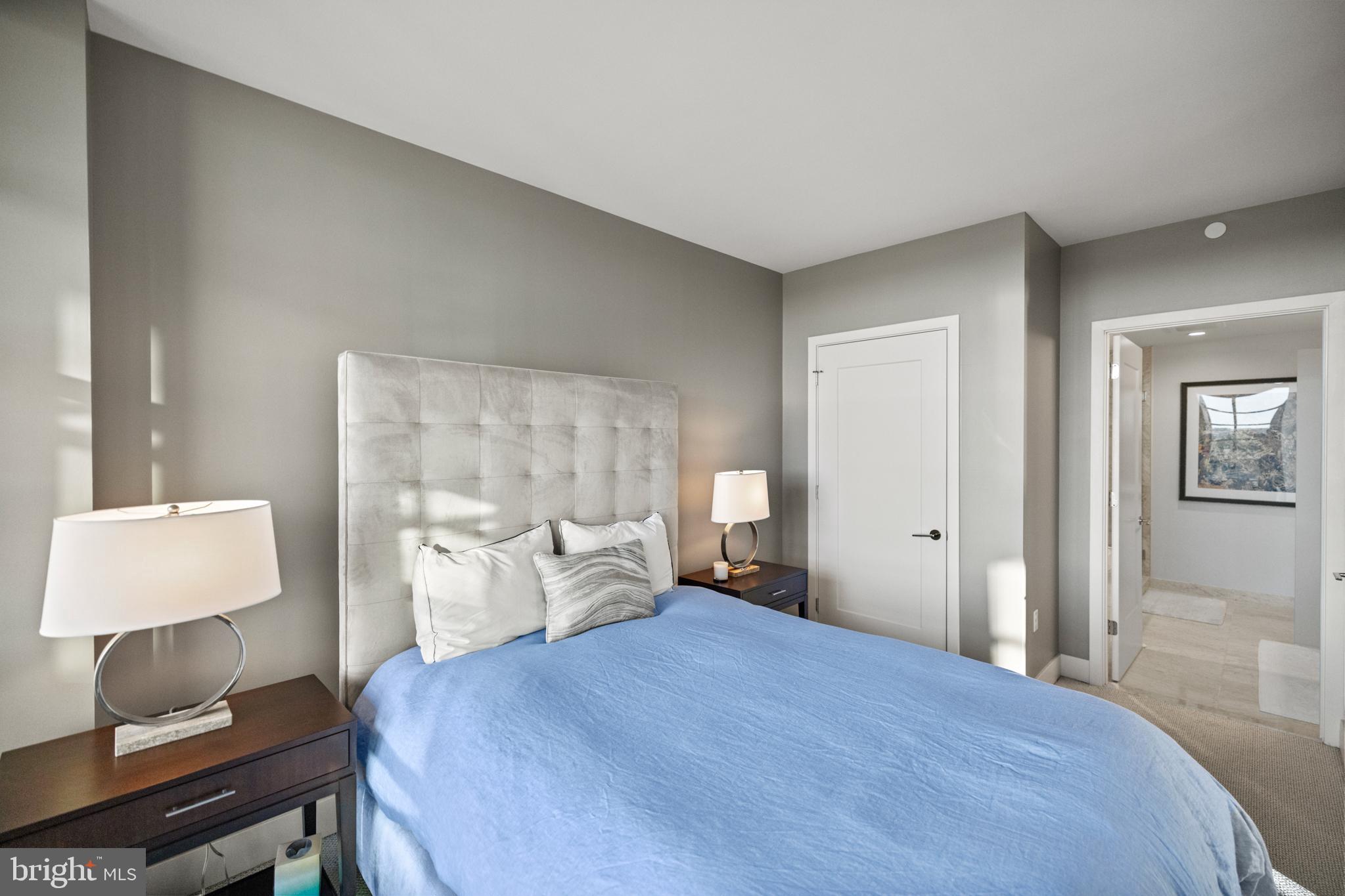 45 Sutton Square Southwest, Unit 503 Washington, DC 20024 - Photo 17 of 50 a bedroom with a bed and a lamp on table