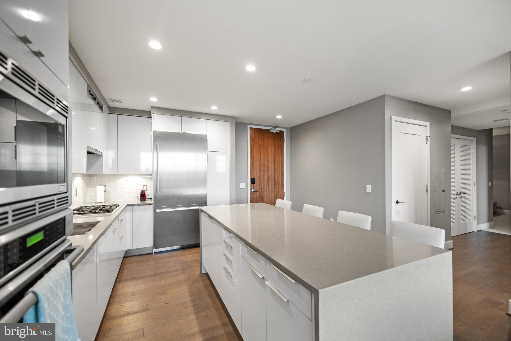 45 Sutton Square Southwest, Unit 503 Washington, DC 20024 - Photo 20 of 50 a large kitchen with stainless steel appliances lots of counter space and wooden floor