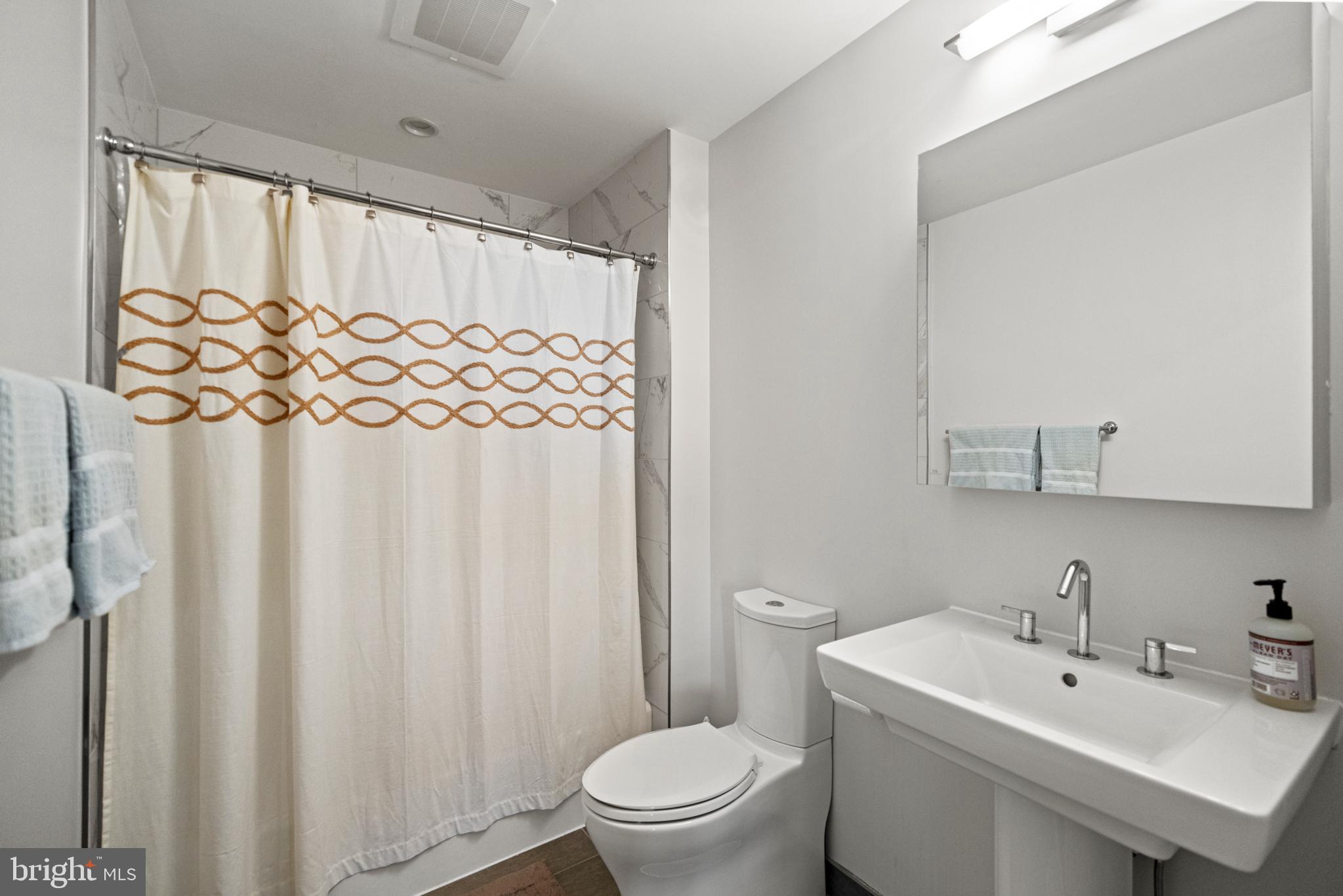 45 Sutton Square Southwest, Unit 503 Washington, DC 20024 - Photo 22 of 50 a bathroom with a sink a toilet and a mirror
