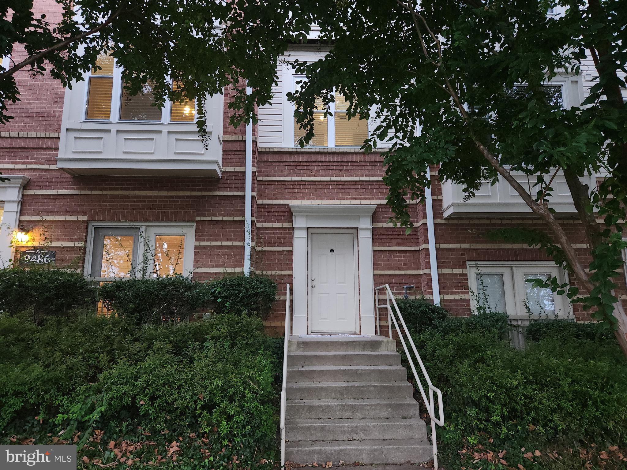 9486 Virginia Center Boulevard, Unit 114 Vienna, VA 22181 - Photo 1 of 41 a front view of a house with trees and plants