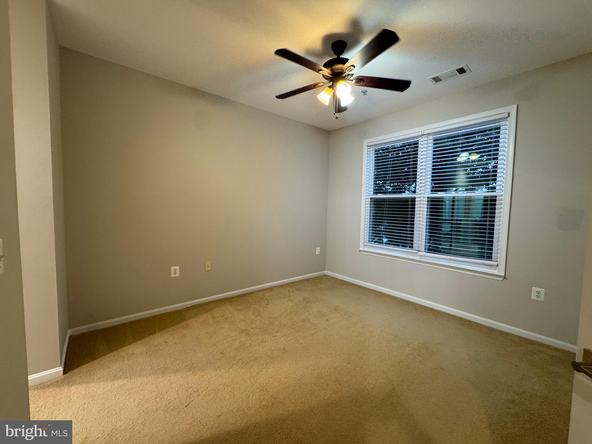 9486 Virginia Center Boulevard, Unit 114 Vienna, VA 22181 - Photo 15 of 41 an empty room with chandelier fan and windows