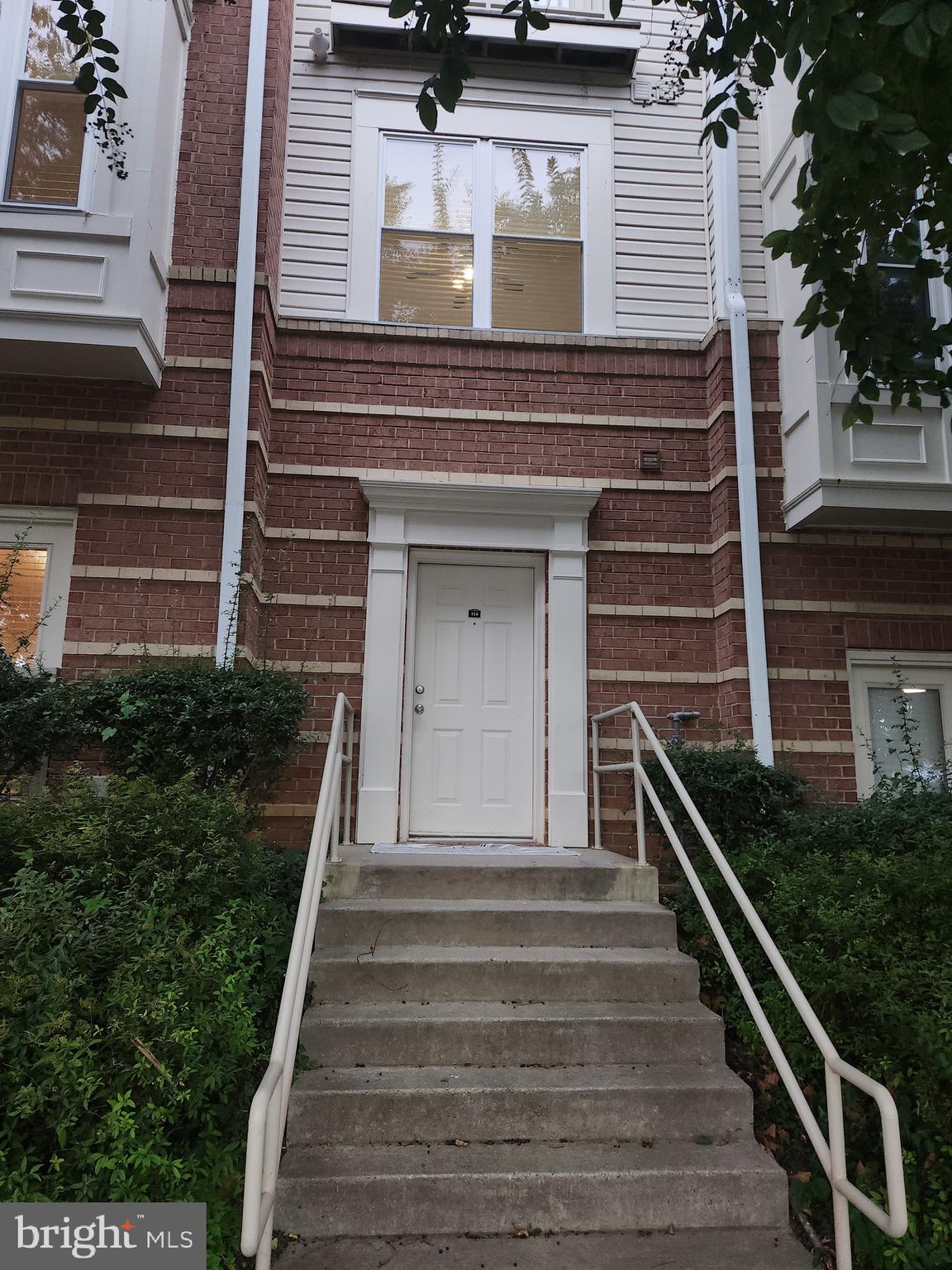 9486 Virginia Center Boulevard, Unit 114 Vienna, VA 22181 - Photo 2 of 41 a front view of a house with potted plants