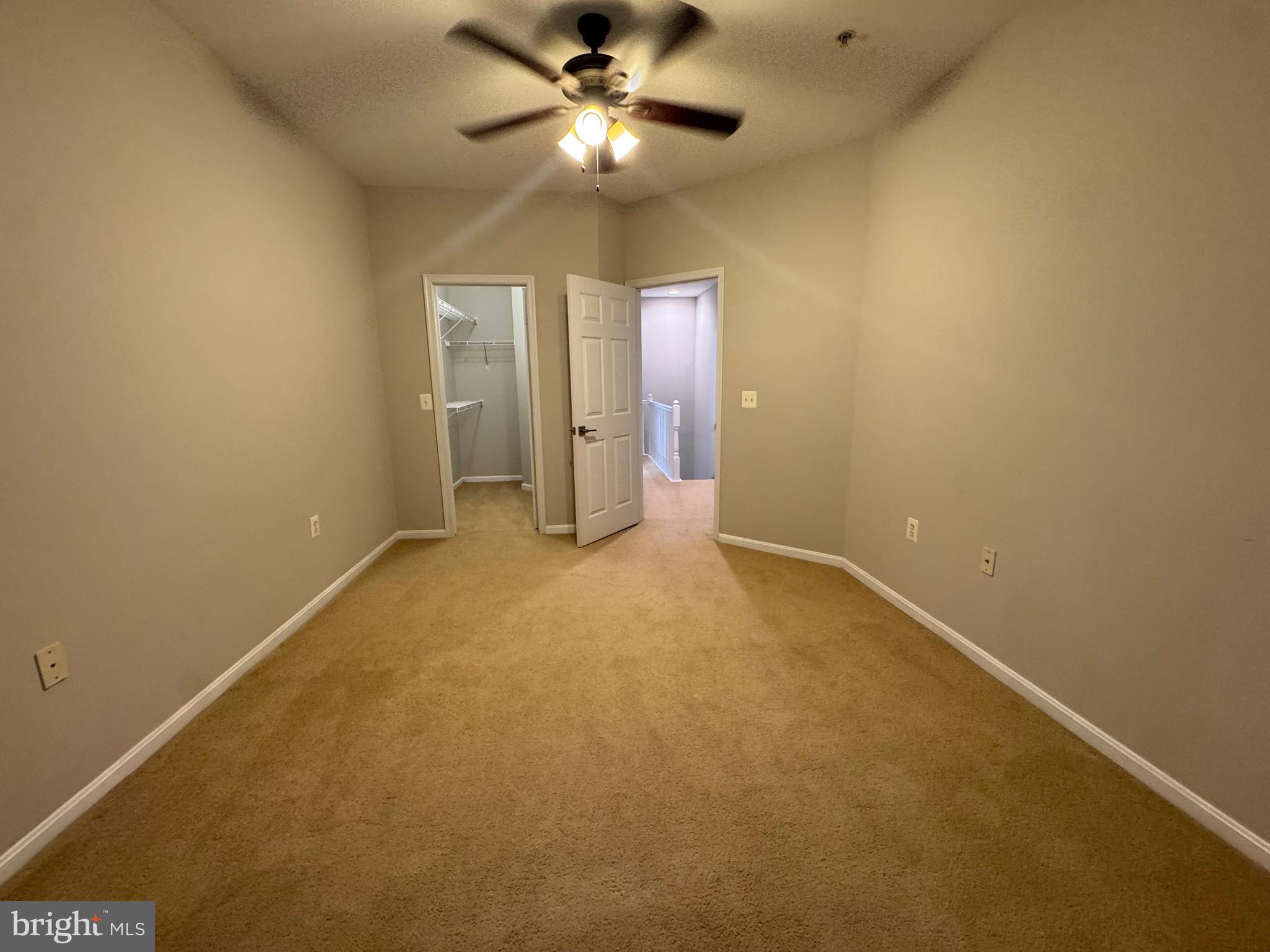 9486 Virginia Center Boulevard, Unit 114 Vienna, VA 22181 - Photo 23 of 41 an empty room with a ceiling fan and a window