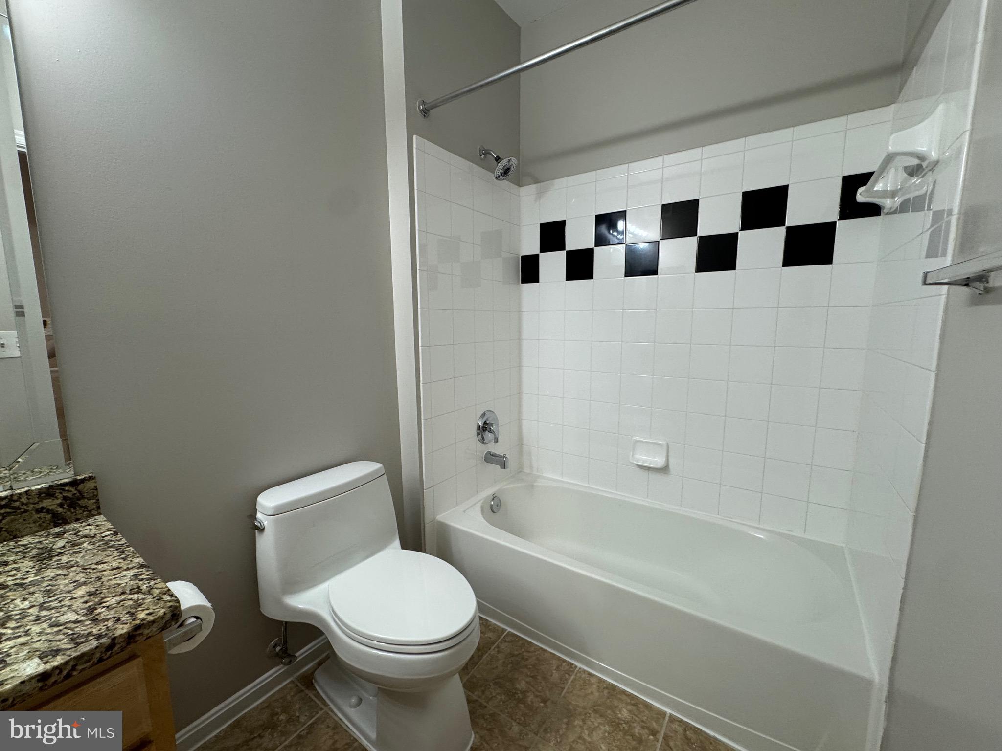 9486 Virginia Center Boulevard, Unit 114 Vienna, VA 22181 - Photo 25 of 41 a white toilet sitting next to a bathroom sink and a tub