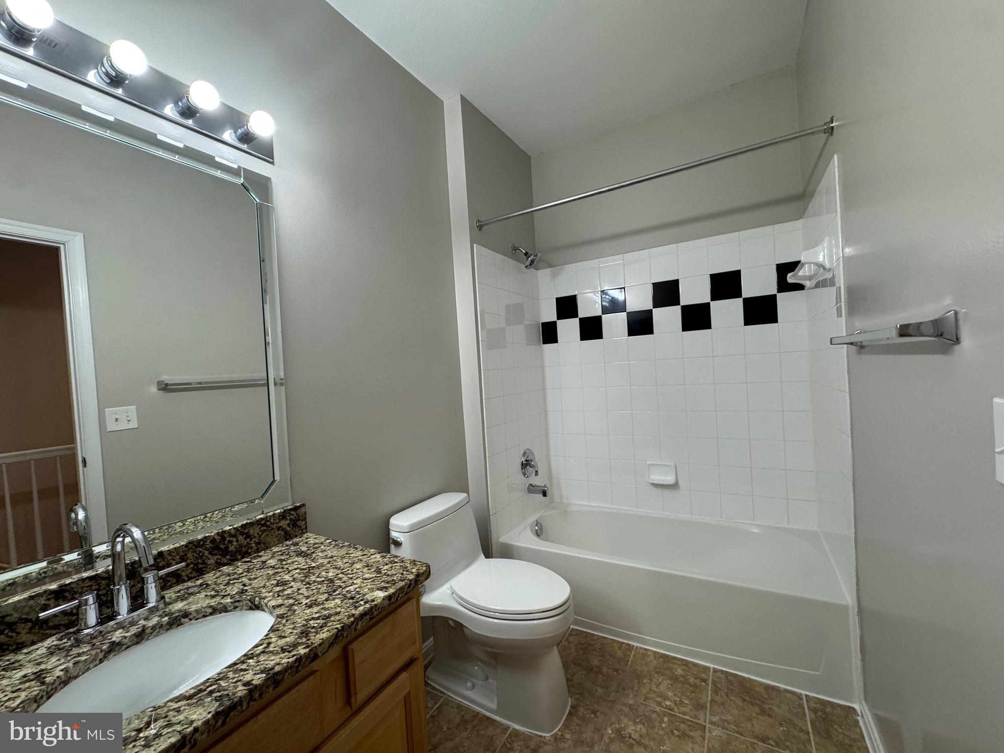 9486 Virginia Center Boulevard, Unit 114 Vienna, VA 22181 - Photo 26 of 41 a bathroom with a granite countertop sink toilet and shower