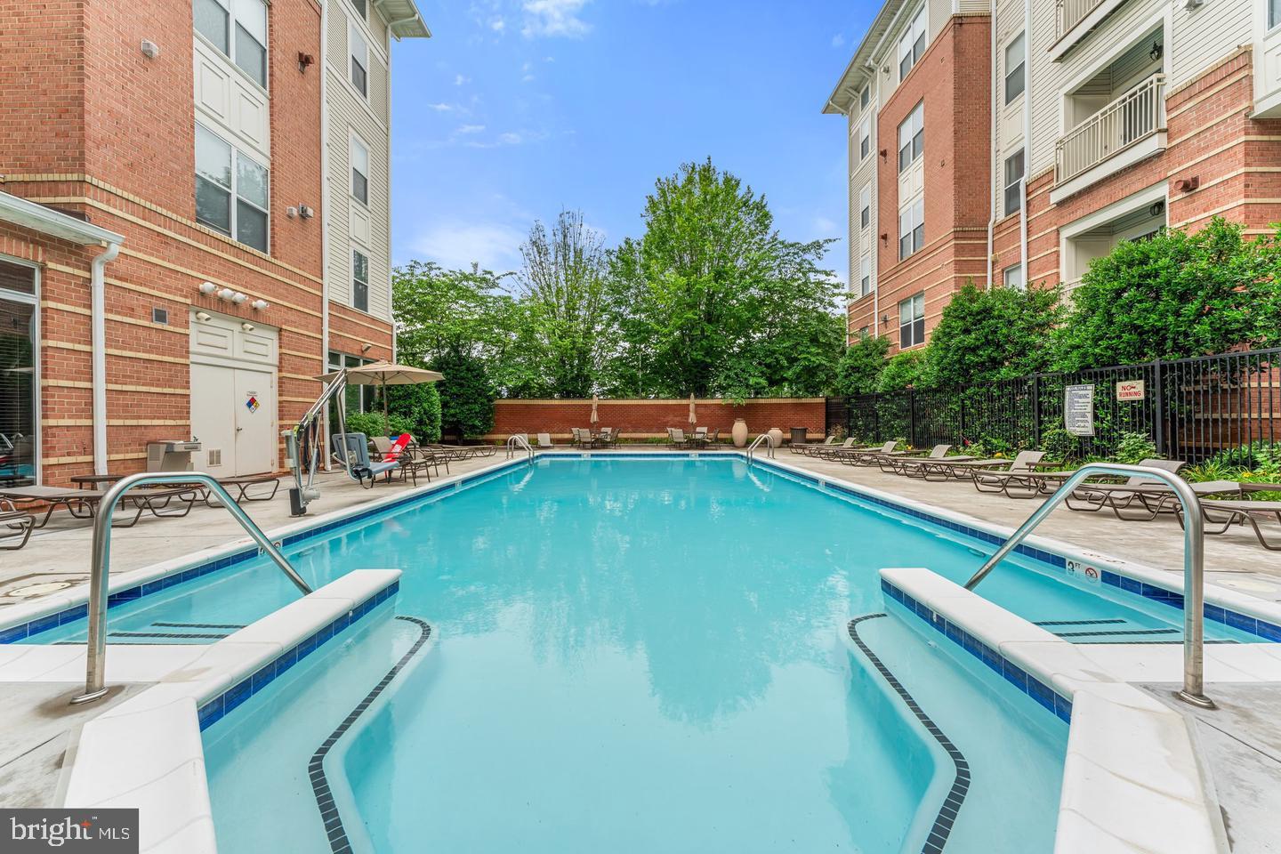 9486 Virginia Center Boulevard, Unit 114 Vienna, VA 22181 - Photo 34 of 41 a view of a swimming pool with a lounge chairs