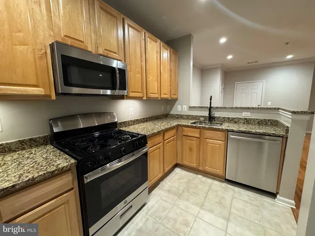 a kitchen with granite countertop a stove sink and microwave