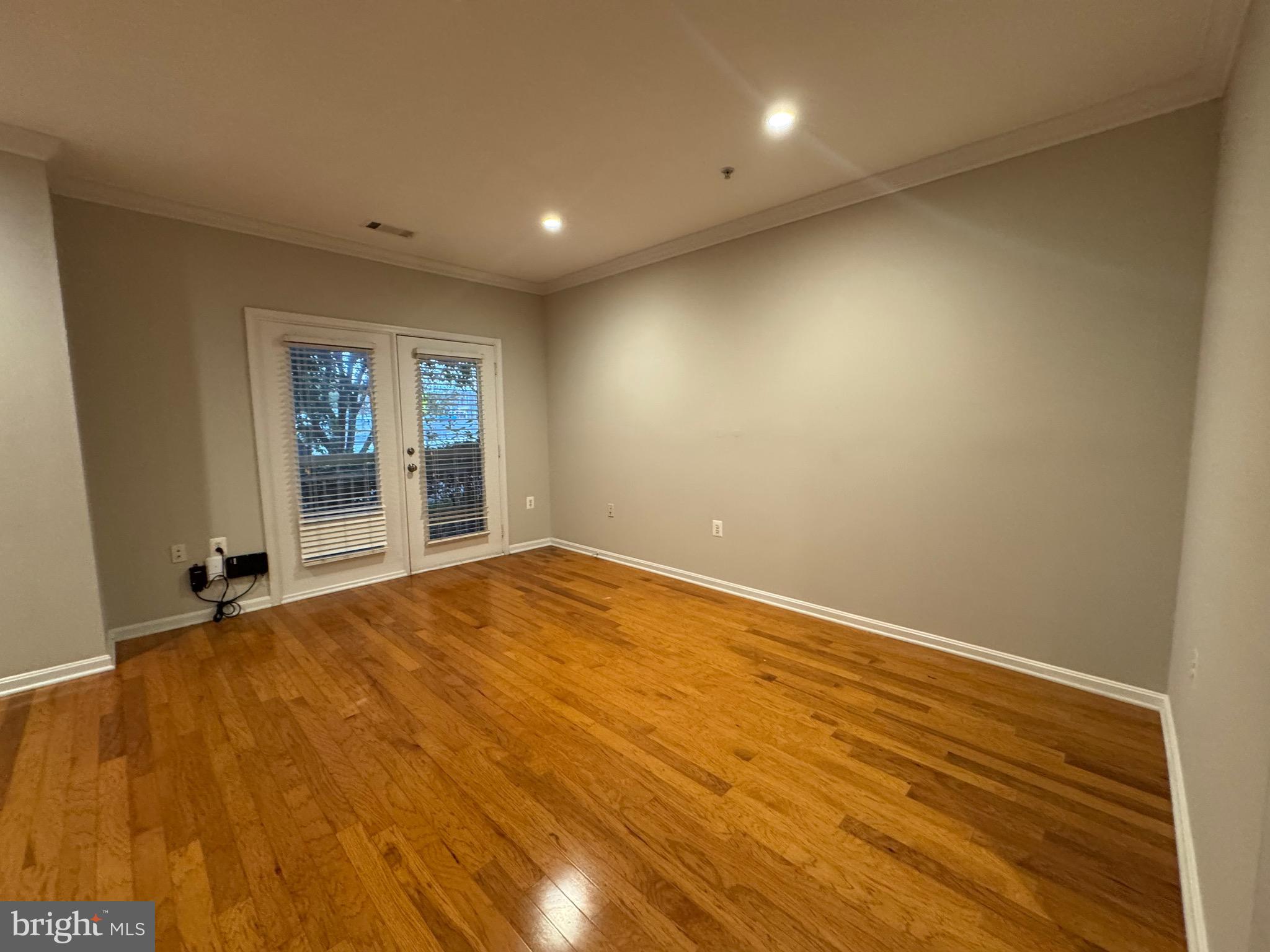 9486 Virginia Center Boulevard, Unit 114 Vienna, VA 22181 - Photo 9 of 41 an empty room with wooden floor and windows