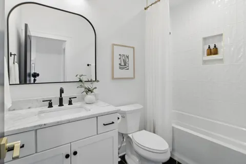 a bathroom with a toilet a sink a mirror and a shower