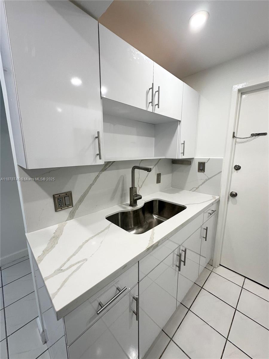 8400 Byron Avenue, Unit 2D Miami Beach, FL 33141 - Photo 11 of 21 a kitchen with a sink and cabinets
