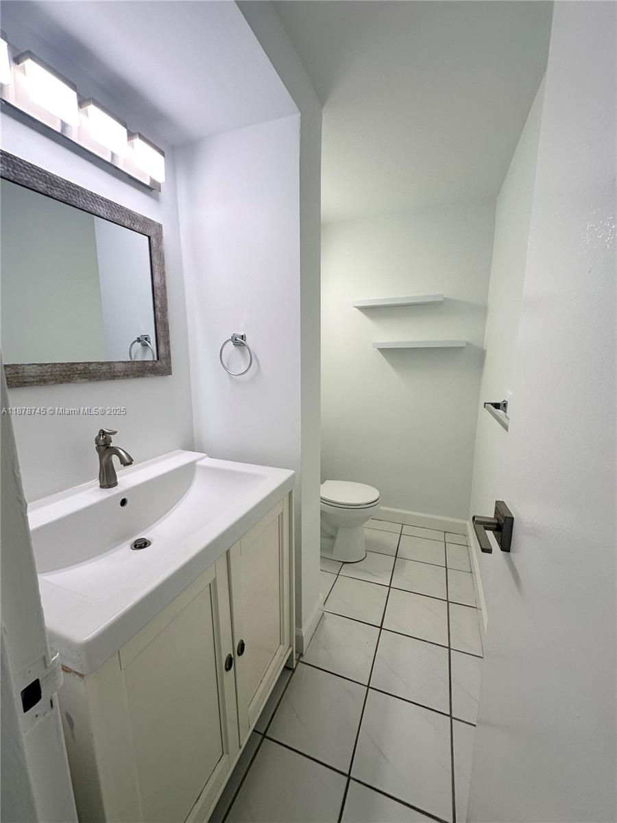 8400 Byron Avenue, Unit 2D Miami Beach, FL 33141 - Photo 9 of 21 a bathroom with a sink toilet and mirror