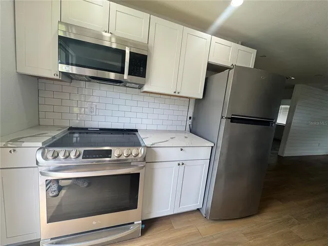 a kitchen with stainless steel appliances granite countertop a sink stove and cabinets