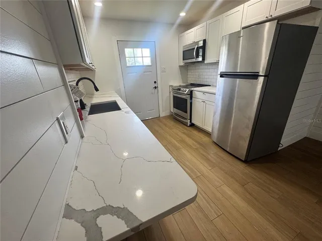 a view of a hallway with wooden floor