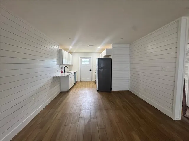 a view of hallway with a large window and wooden floor