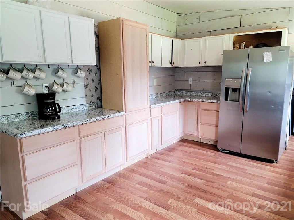525 Baker Mill Road Cleveland, NC 27013 - Photo 21 of 35 a kitchen with stainless steel appliances granite countertop a refrigerator sink and white cabinets
