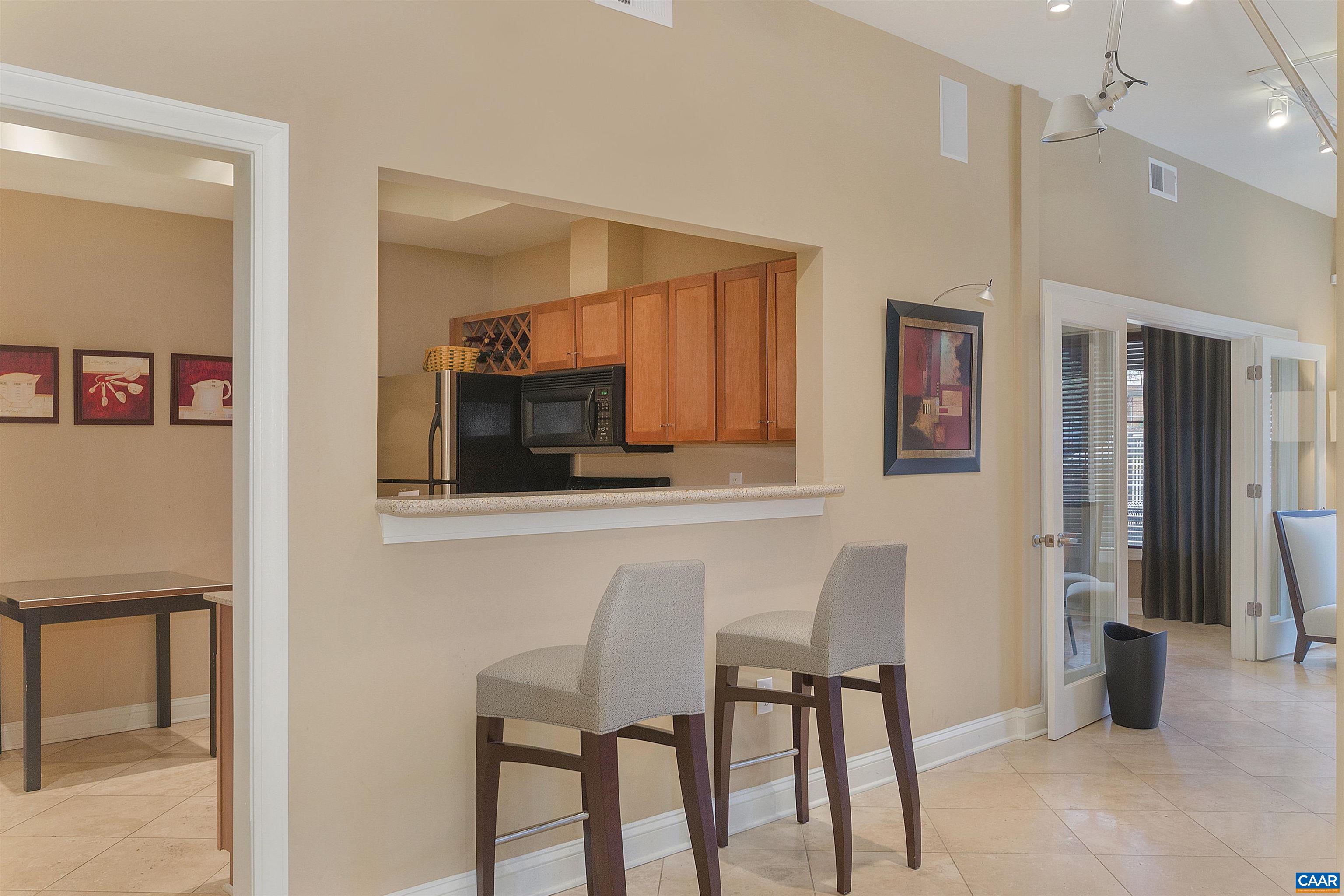 720 Walker Square, Unit 3D Charlottesville, VA 22903 - Photo 12 of 26 a kitchen with stainless steel appliances kitchen island granite countertop a refrigerator and microwave