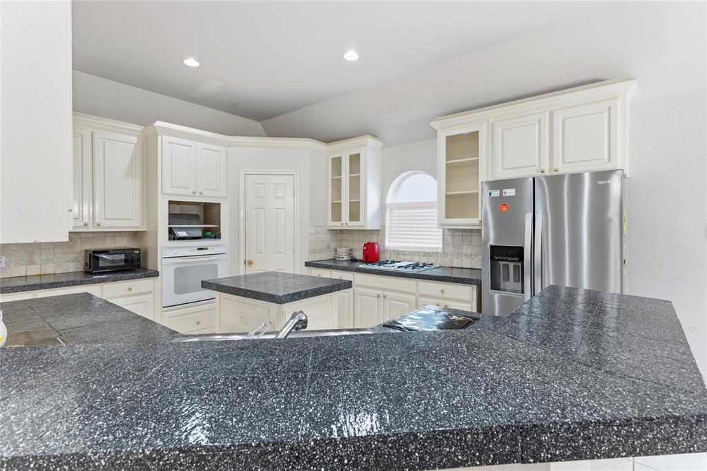 2505 Timber Ridge Drive Garland, TX 75044 - Photo 12 of 38 a large kitchen with granite countertop a stove refrigerator and a sink