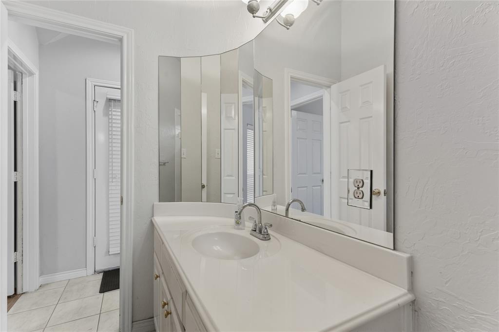 2505 Timber Ridge Drive Garland, TX 75044 - Photo 31 of 38 a bathroom with a sink a mirror and a shower