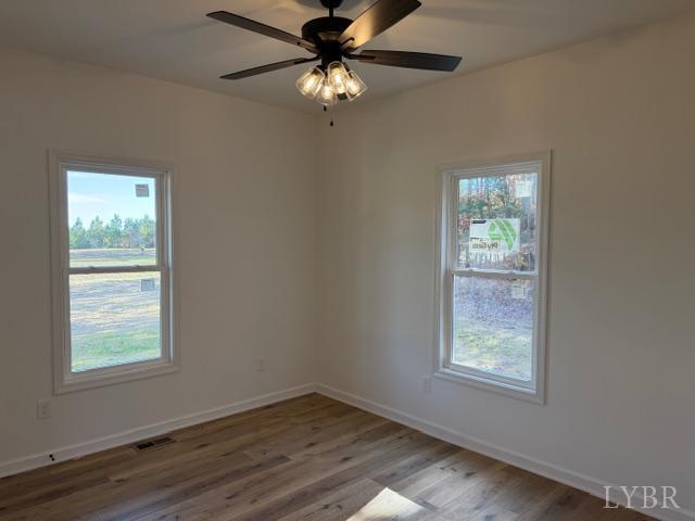 689 Robinson Road Appomattox, VA 24522 - Photo 12 of 16 an empty room with wooden floor fan and windows