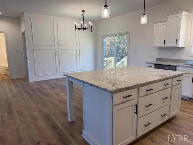 a kitchen with granite countertop cabinets and wooden floor