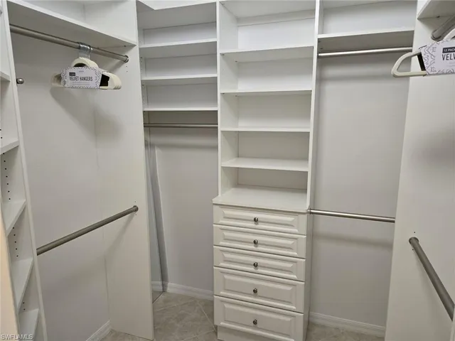a view of walk in closet with empty racks