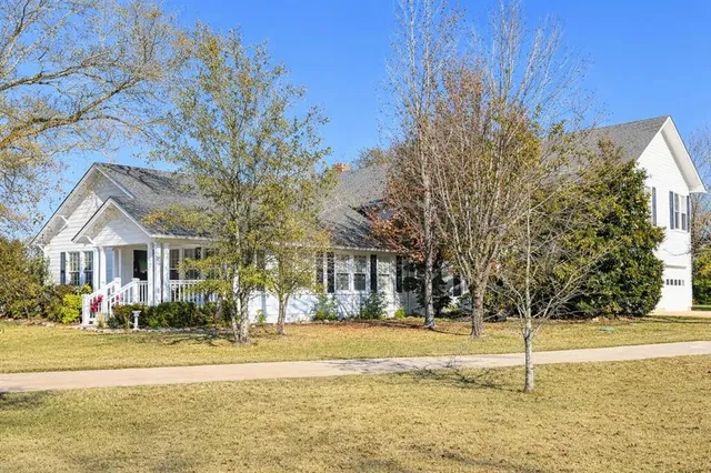 a front view of house with yard and trees around