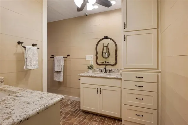 a bathroom with a granite countertop sink a vanity and a mirror