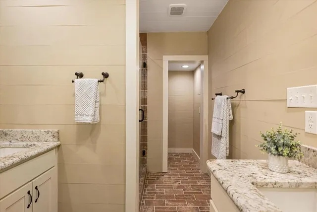 a bathroom with a granite countertop sink a shower and a mirror