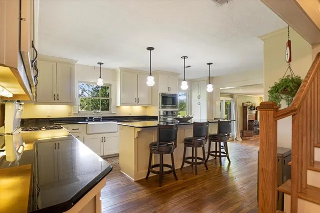 a kitchen with stainless steel appliances a dining table chairs stove a refrigerator and cabinets