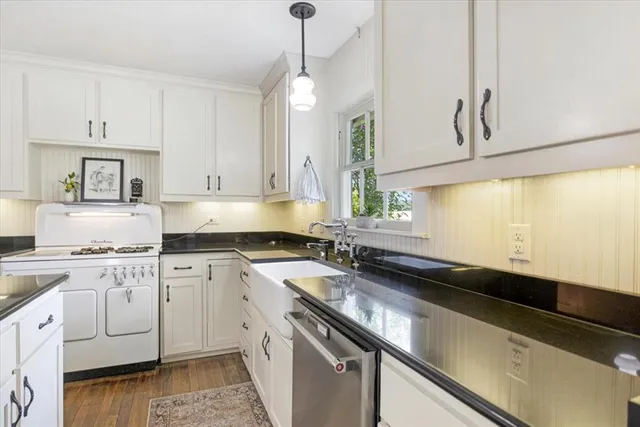 a kitchen with granite countertop white cabinets and white appliances