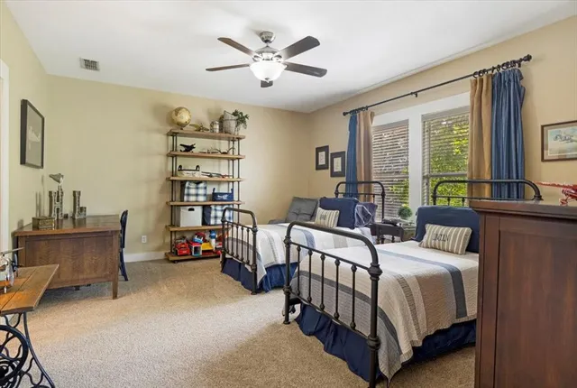 a bedroom with a bed a large window and book shelf