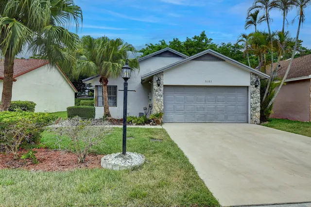 a front view of a house with a yard and garage