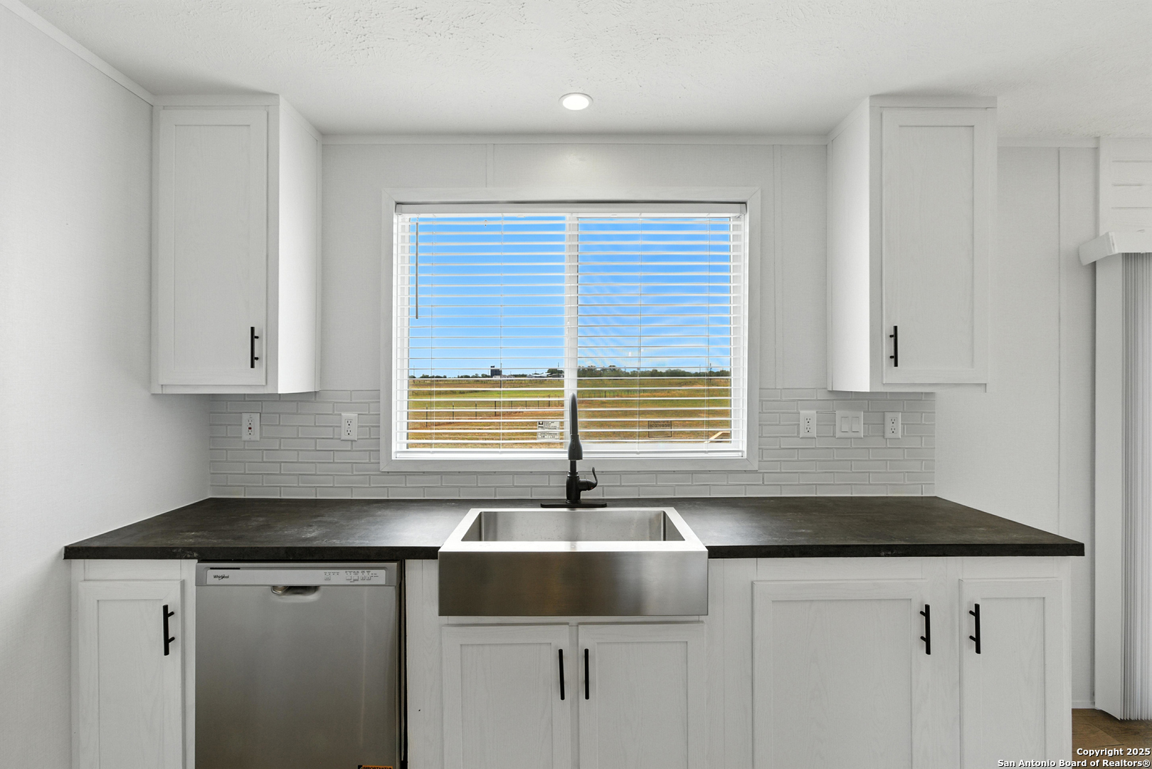 2479 Fm 1332 Jourdanton, TX 78026 - Photo 9 of 18 a kitchen with granite countertop white cabinets sink and window