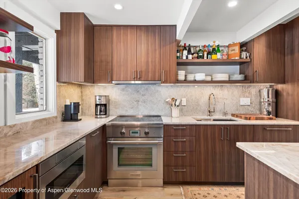 a kitchen with stainless steel appliances granite countertop a stove a sink dishwasher and cabinets with wooden floor