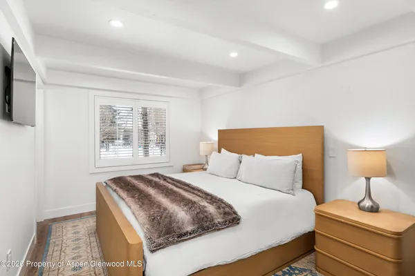 a bedroom with a bed and a lamp on dresser