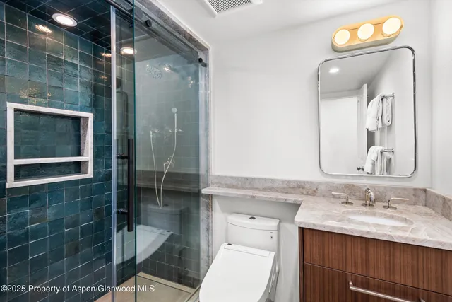 a bathroom with a sink shower and a mirror