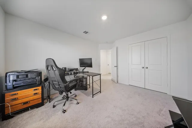 a view of a workspace with furniture and a window