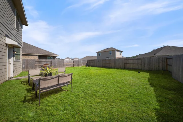 a backyard of a house with table and chairs