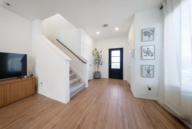 a view of a livingroom with wooden floor and furniture