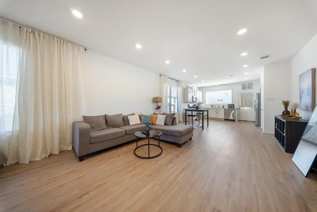 a living room with furniture and a wooden floor