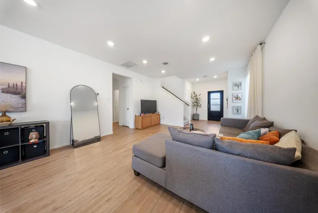 a living room with furniture and a wooden floor