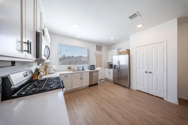a large kitchen with a wooden floor and a stove top oven