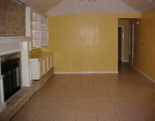 a view of a livingroom with an empty space and a fireplace