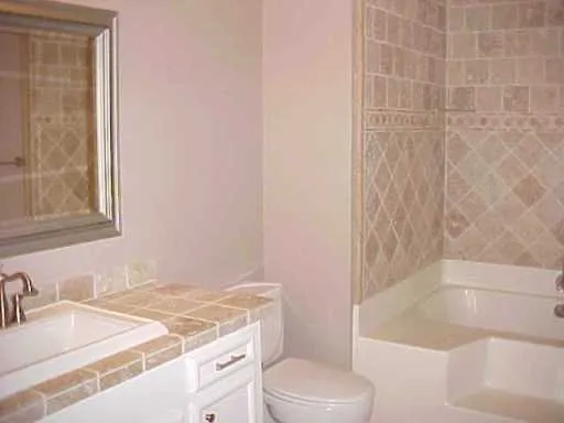 a bathroom with a granite countertop sink a toilet and bathtub