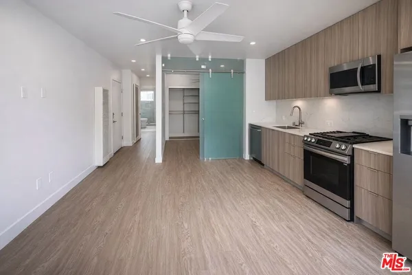 a kitchen with stainless steel appliances a stove top oven a sink and a refrigerator